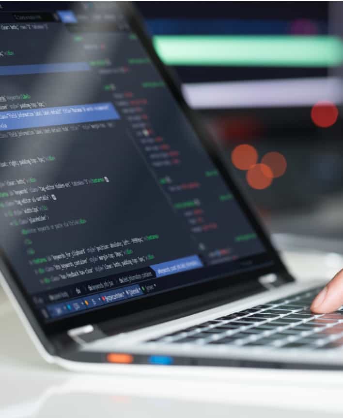 Silver laptop displaying code.