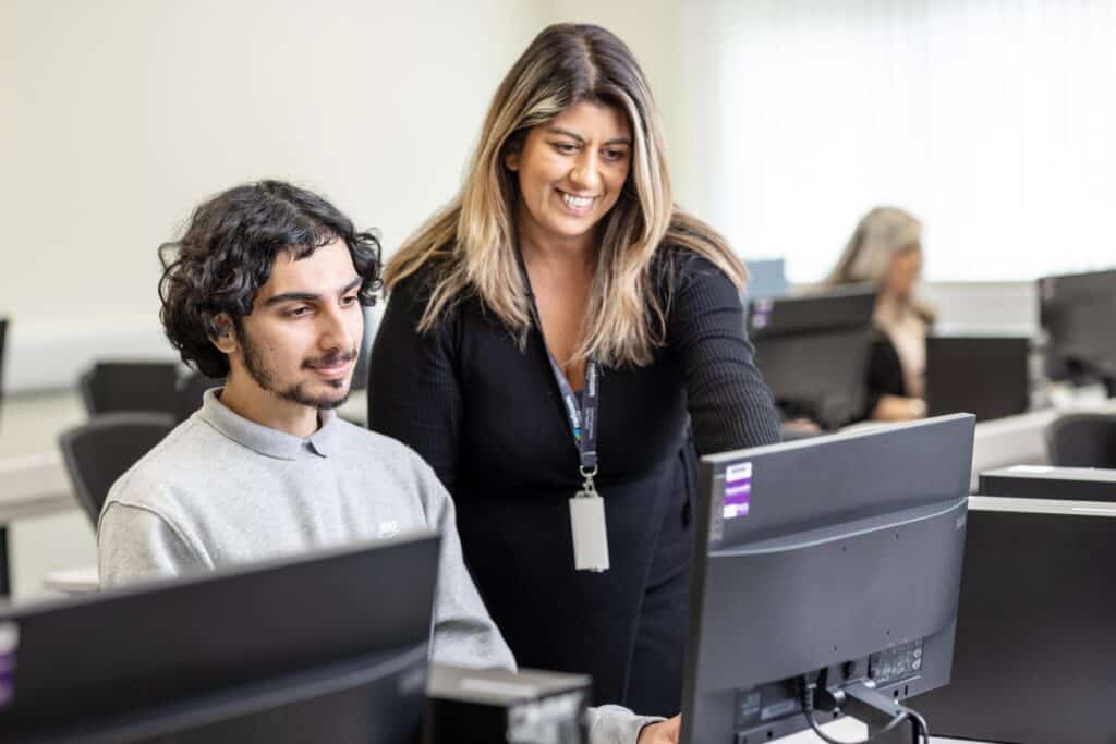 Photo of teaching staff supporting a student