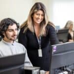 Photo of teaching staff supporting a student